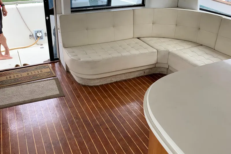  Yacht Photos Pics 1999 Bayliner 5788 Pilot House Motoryacht interior with white seating and wooden flooring.