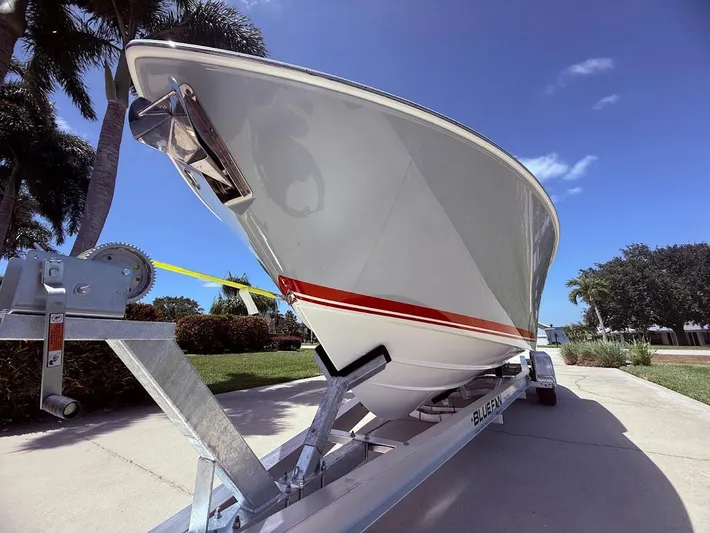  Yacht Photos Pics 2020 Pursuit DC 266 Dual Console boat on trailer, sunny day, palm trees in background.