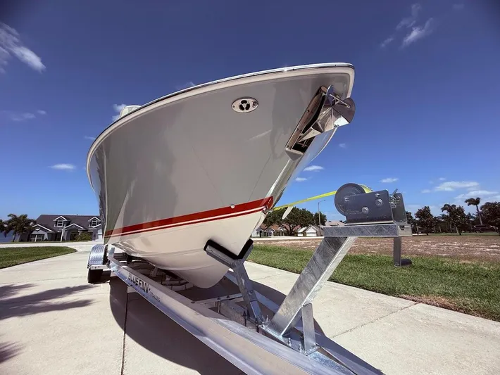  Yacht Photos Pics 2020 Pursuit DC 266 Dual Console boat on trailer under clear blue sky.