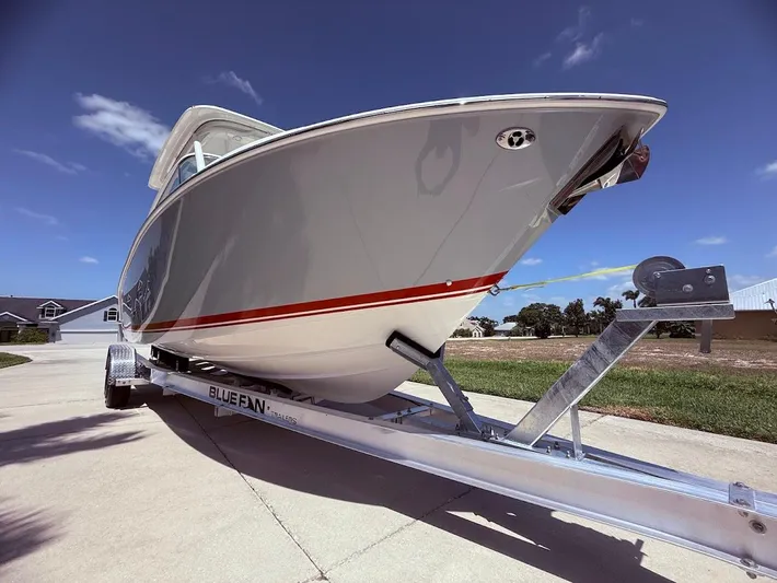  Yacht Photos Pics 2020 Pursuit DC 266 Dual Console boat on trailer under clear blue sky.