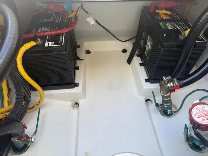  Yacht Photos Pics Battery compartment of a 2020 Pursuit DC 266 Dual Console boat, featuring dual batteries and wiring.