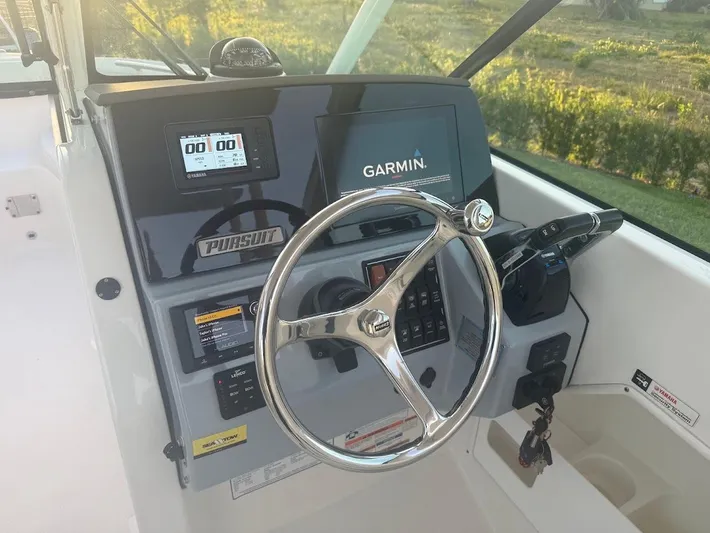  Yacht Photos Pics 2020 Pursuit DC 266 Dual Console boat dashboard with Garmin navigation system and steering wheel.