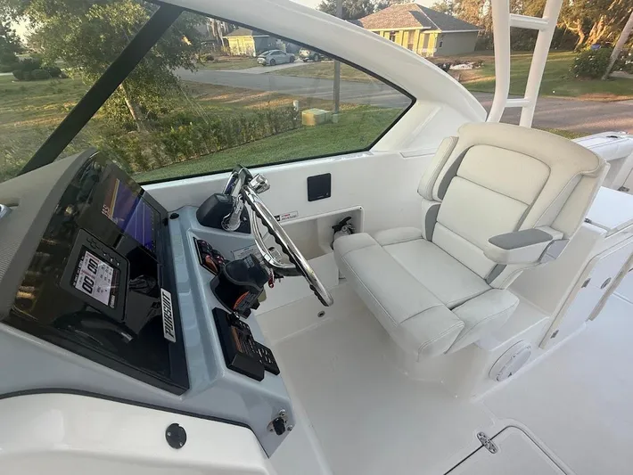  Yacht Photos Pics 2020 Pursuit DC 266 Dual Console boat interior with helm and captain's chair.