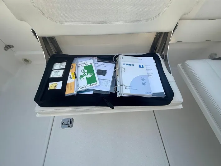  Yacht Photos Pics 2020 Pursuit DC 266 Dual Console boat seat storage with manuals and documents.