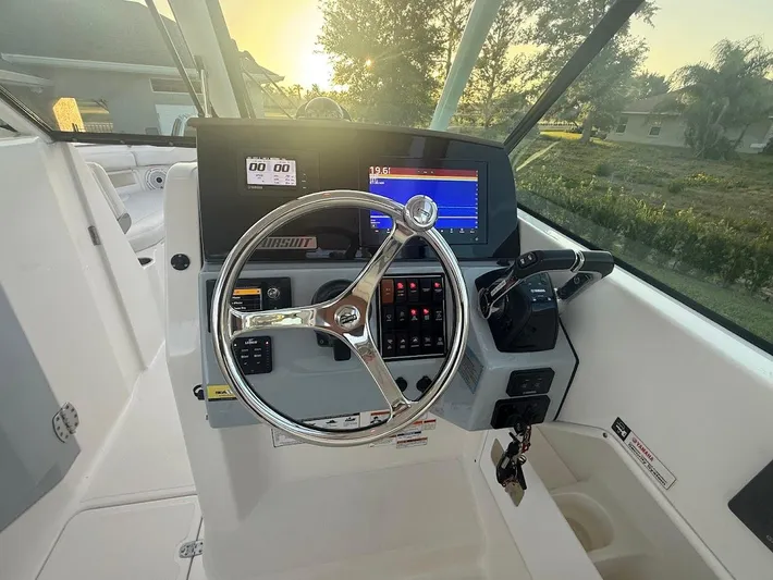  Yacht Photos Pics 2020 Pursuit DC 266 Dual Console boat dashboard with steering wheel and navigation controls.