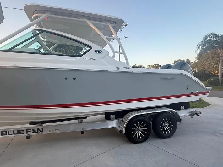  Yacht Photos Pics 2020 Pursuit DC 266 Dual Console boat on a trailer, parked outdoors.
