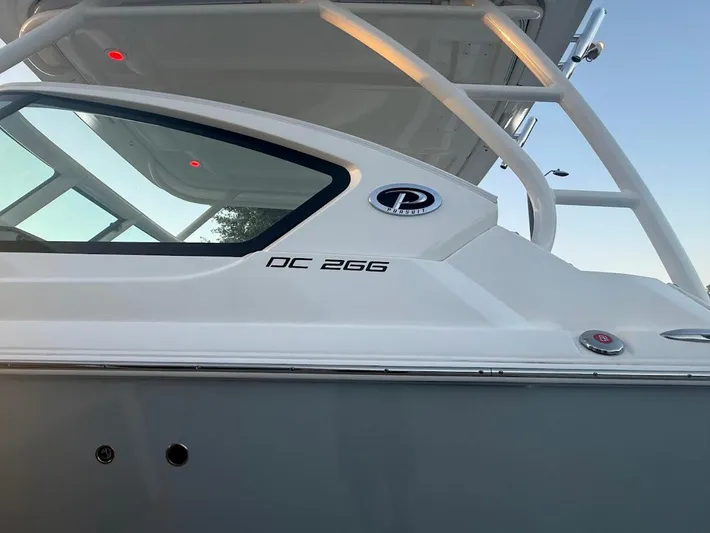  Yacht Photos Pics 2020 Pursuit DC 266 Dual Console boat side view with logo and model name.