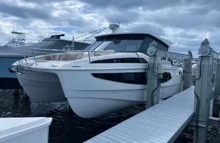  Yacht Photos Pics 2023 Aquila 36 Sport catamaran docked under cloudy skies.