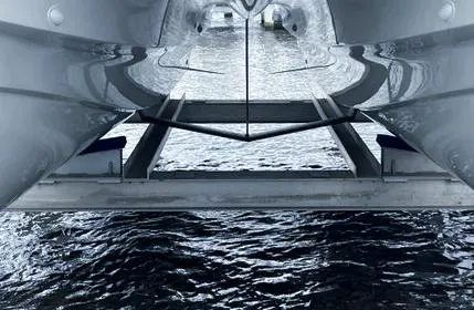  Yacht Photos Pics Underwater view of 2023 Aquila 36 Sport catamaran hull reflecting on water.