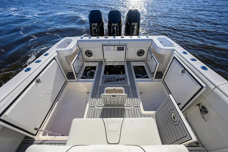 Barefoot In Public Yacht Photos Pics 2023 SeaVee 370Z boat deck with open storage compartments and triple outboard motors.