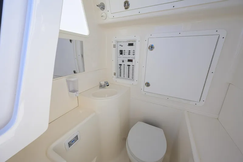 Barefoot In Public Yacht Photos Pics 2023 SeaVee 370Z boat interior bathroom with sink, toilet, and control panel.