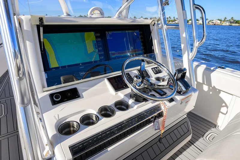 Barefoot In Public Yacht Photos Pics 2023 SeaVee 370Z boat dashboard with navigation screens and steering wheel on open water.