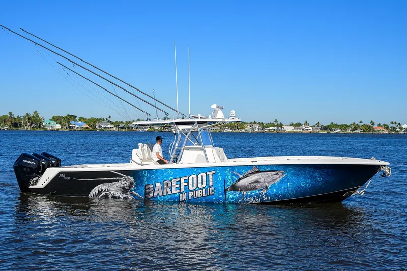 Barefoot In Public Yacht Photos Pics 2023 SeaVee 370Z boat with vibrant marine graphics, cruising on a sunny day.