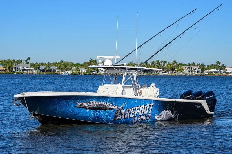 Barefoot In Public Yacht Photos Pics 2023 SeaVee 370Z boat with vibrant marine graphics on a calm waterway.