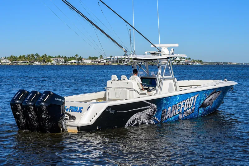 Barefoot In Public Yacht Photos Pics 2023 SeaVee 370Z boat with vibrant graphics, triple Mercury engines, cruising on a sunny day.