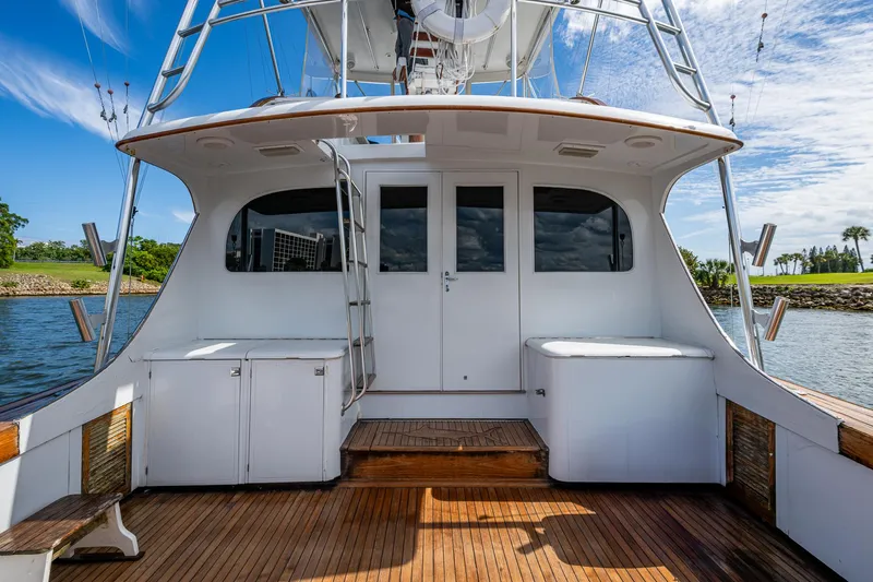 Able Hand Yacht Photos Pics 1978 Graves 51 yacht deck with wooden flooring and white cabinetry, under a clear blue sky.