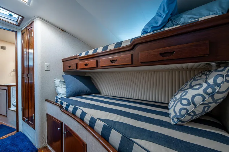 Able Hand Yacht Photos Pics Cozy 1978 Graves 51 yacht cabin with striped bedding and wooden storage.