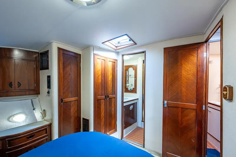 Able Hand Yacht Photos Pics Interior of a 1978 Graves 51 yacht cabin with wooden furnishings and blue bedding.