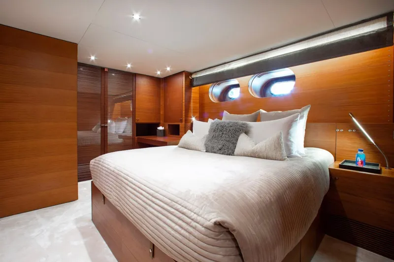 Matrix Yacht Photos Pics Luxurious bedroom interior on 1999 Baglietto 41M yacht with modern wood paneling and plush bedding.