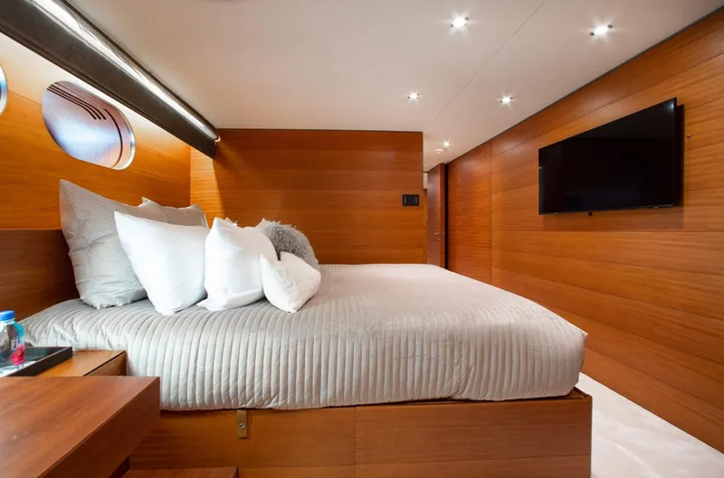 Matrix Yacht Photos Pics Luxurious bedroom interior on 1999 Baglietto 41M yacht with wood paneling and modern decor.