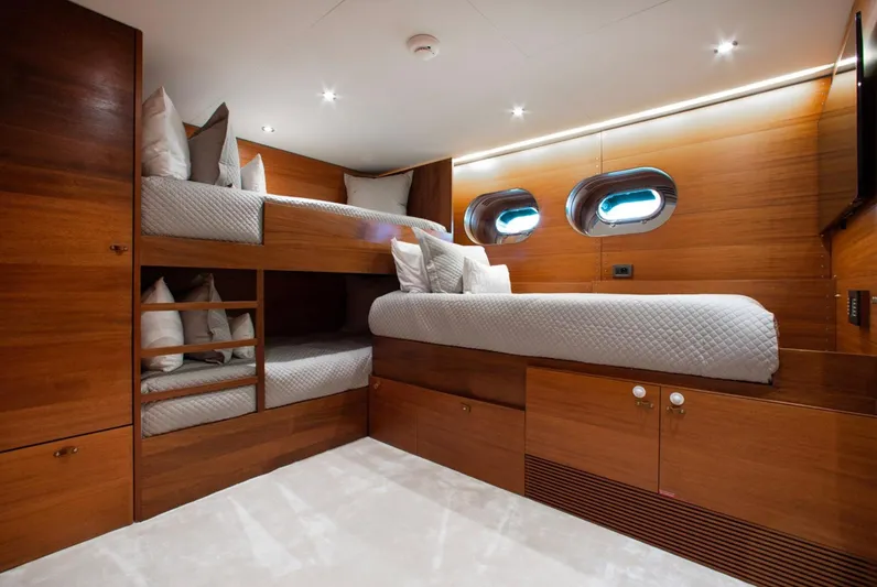 Matrix Yacht Photos Pics Luxurious cabin interior of 1999 Baglietto 41M yacht with wooden finish and cozy bedding.
