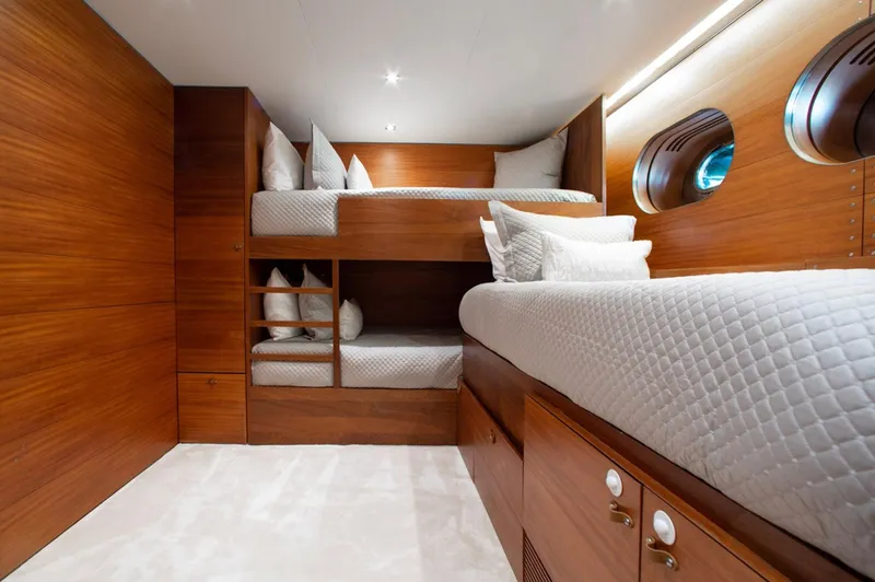 Matrix Yacht Photos Pics Luxurious cabin interior of 1999 Baglietto 41M yacht with wooden finish and cozy bedding.