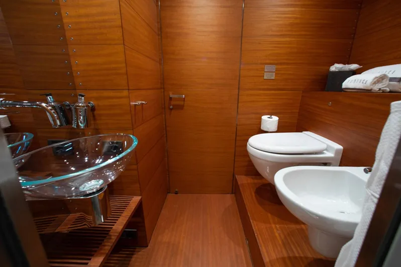 Matrix Yacht Photos Pics Luxurious wooden bathroom interior on 1999 Baglietto 41M yacht, featuring modern fixtures and glass sink.