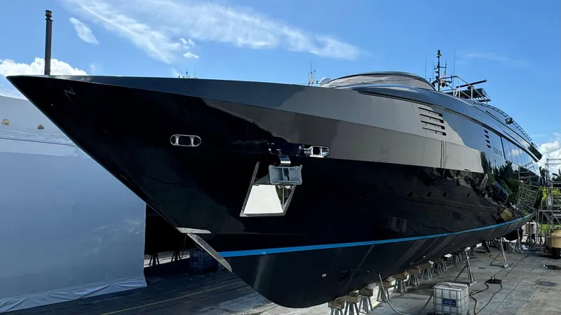 Matrix Yacht Photos Pics Luxurious 1999 Baglietto 41M yacht with sleek black design, docked under clear blue sky.