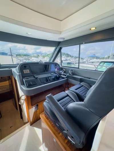  Yacht Photos Pics 2024 Riviera 465 SUV helm with luxurious seating and panoramic marina view.