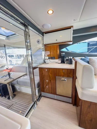  Yacht Photos Pics 2024 Riviera 465 SUV interior with modern kitchen and seating area.