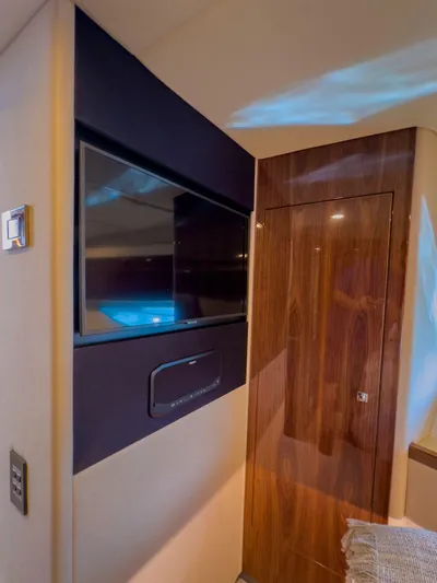  Yacht Photos Pics Interior of 2024 Riviera 465 SUV featuring a sleek TV and wooden door.