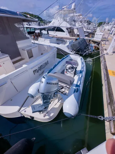  Yacht Photos Pics 2024 Riviera 465 SUV docked with inflatable boat, featuring Honda outboard motor.