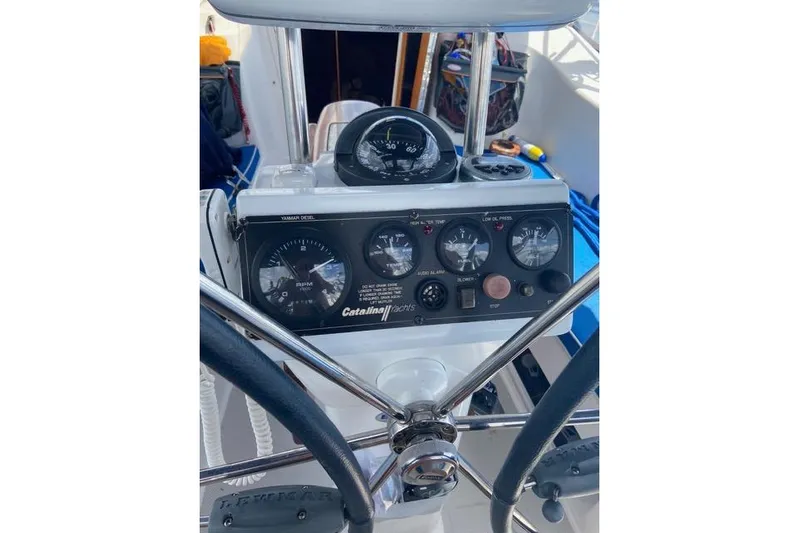 Perfect Timing Yacht Photos Pics Cockpit controls of a 2011 Catalina 355 sailboat, featuring gauges and steering wheel.