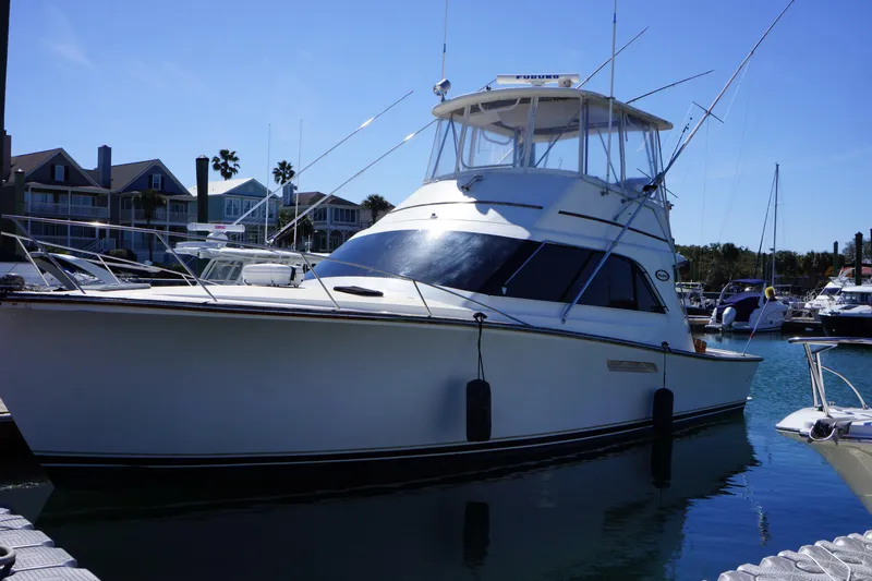 The Dog House Yacht Photos Pics 1988 Ocean Yachts Super Sport docked in a marina under clear blue skies.