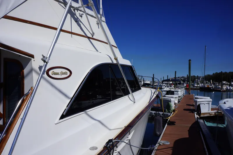 The Dog House Yacht Photos Pics 1988 Ocean Yachts Super Sport docked at a marina under clear blue skies.