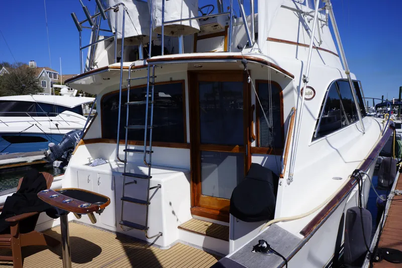The Dog House Yacht Photos Pics 1988 Ocean Yachts Super Sport docked, showcasing rear deck and ladder.