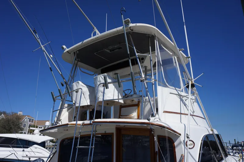 The Dog House Yacht Photos Pics 1988 Ocean Yachts Super Sport boat with fishing rods and flybridge, docked at marina.