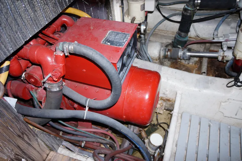 The Dog House Yacht Photos Pics Engine compartment of 1988 Ocean Yachts Super Sport, featuring red machinery and hoses.
