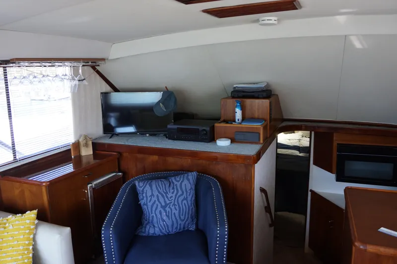 The Dog House Yacht Photos Pics Interior of 1988 Ocean Yachts Super Sport with TV, seating, and wooden cabinetry.