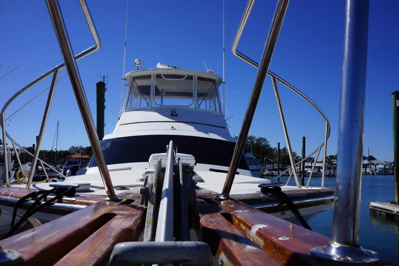 The Dog House Yacht Photos Pics 1988 Ocean Yachts Super Sport boat docked, viewed from the bow under a clear blue sky.