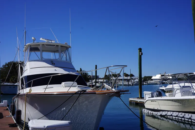 The Dog House Yacht Photos Pics 1988 Ocean Yachts Super Sport docked at a marina under clear blue skies.