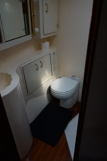 The Dog House Yacht Photos Pics 1988 Ocean Yachts Super Sport bathroom with toilet, cabinets, and wooden flooring.