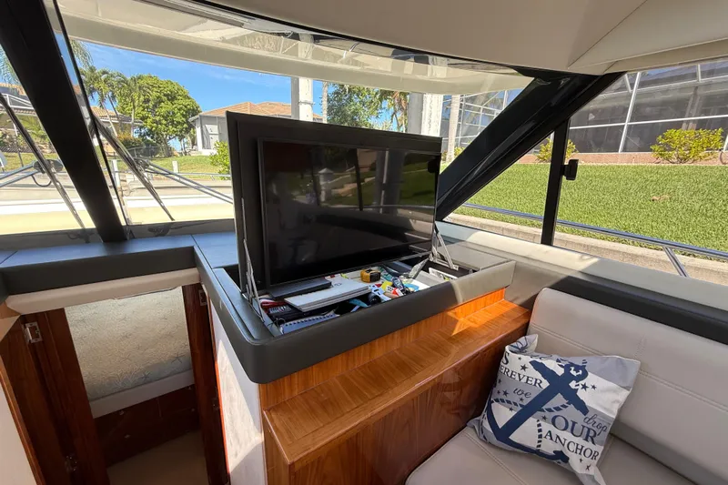  Yacht Photos Pics Interior of 2021 Riviera 395 SUV with pop-up TV and decorative pillow.