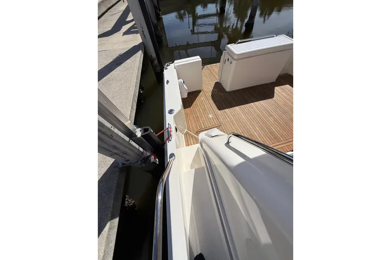  Yacht Photos Pics 2021 Riviera 395 SUV boat deck with wooden flooring and dock view.