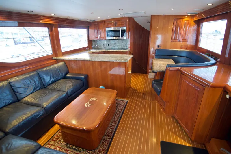 Grape Escape Yacht Photos Pics Luxurious interior of 2000 Hatteras 60 Convertible yacht with leather seating and wood finishes.