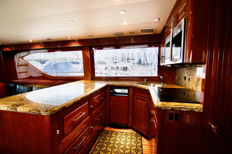 Grape Escape Yacht Photos Pics Luxurious kitchen interior of 2000 Hatteras 60 Convertible yacht with wood cabinetry and granite countertops.