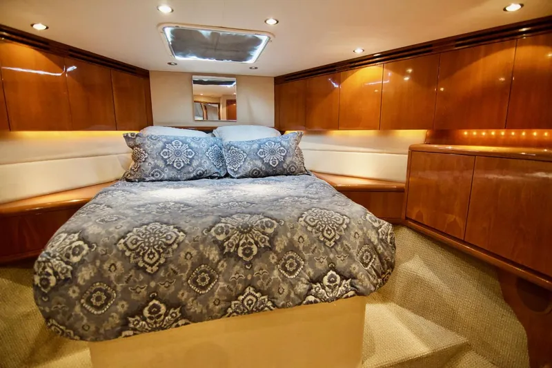 Grape Escape Yacht Photos Pics Luxurious bedroom interior of 2000 Hatteras 60 Convertible yacht with elegant wood cabinetry.