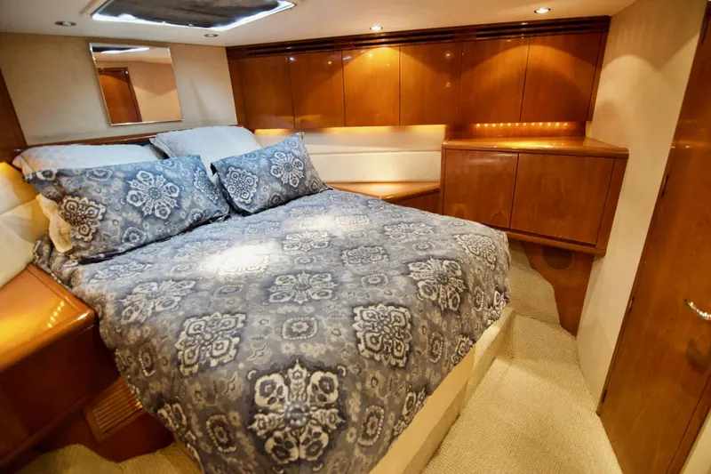 Grape Escape Yacht Photos Pics Luxurious bedroom interior of 2000 Hatteras 60 Convertible yacht with elegant wood cabinetry.