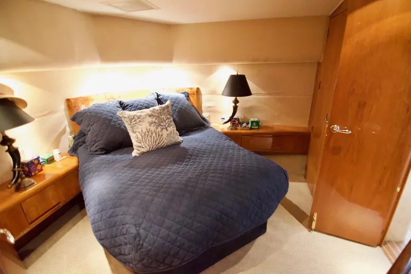 Grape Escape Yacht Photos Pics Luxurious bedroom interior of 2000 Hatteras 60 Convertible yacht with cozy bedding.