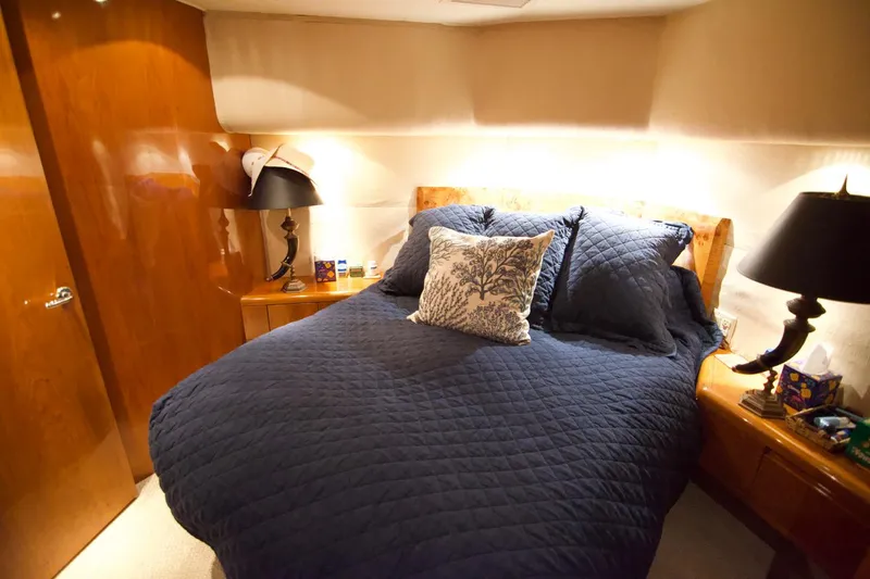 Grape Escape Yacht Photos Pics Luxurious bedroom interior on 2000 Hatteras 60 Convertible yacht with navy bedding.
